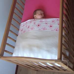 Baby in kort opgemaakt bed